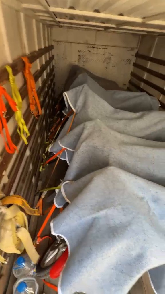 Motos cubiertas con mantas y atadas dentro de la caja del camión